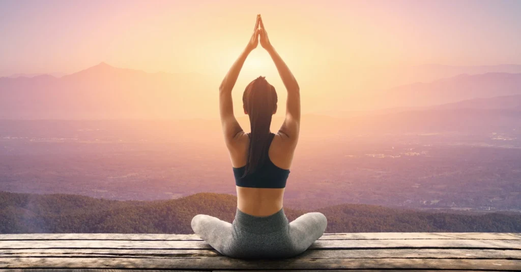 Person laver yoga ved solnedgang som en del af træning og yoga hjemme med fokus på mobilitet og mental klarhed.